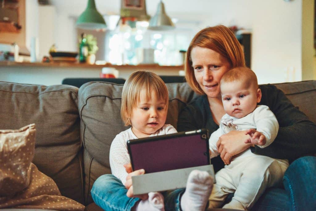 mom with two kids with ipad